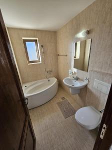 a bathroom with a tub and a toilet and a sink at La Rocca in Fundata