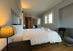 ein Schlafzimmer mit einem weißen Bett mit einer Lampe und einem Fenster in der Unterkunft Maison Linda - Ponte Milvio Apartment in Rom