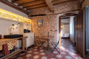 eine Küche mit einem Tisch und einer Ziegelwand in der Unterkunft Appartamento Cordiale in Savigno