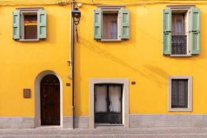 ein gelbes Gebäude mit Fenstern und einer Tür in der Unterkunft Appartamento Cordiale in Savigno