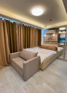 a bedroom with a large bed and a couch at Near AYALA-Charming Studio with Balcony&Great View in Cebu City