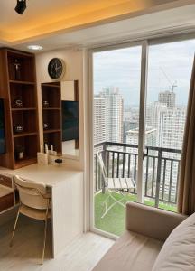 a bedroom with a desk and a large window at Near AYALA-Charming Studio with Balcony&Great View in Cebu City