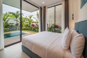 a bedroom with a large bed and a large window at Sunny Village Berawa in Canggu +37 photos