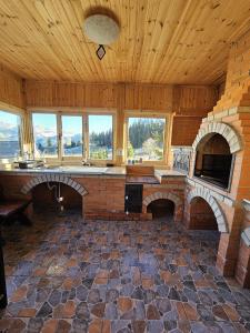 Habitación grande con chimenea de ladrillo y ventanas. en La Rocca, en Fundata