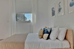 a bedroom with a bed with pillows and a window at Phaedrus Living: City Center Residences Emerald in Nicosia