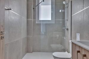 a bathroom with a shower and a toilet and a sink at Phaedrus Living: City Center Residences Emerald in Nicosia