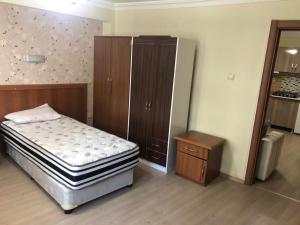 a bedroom with a bed and a dresser and a cabinet at Ortadoğu apart otel in Agrı