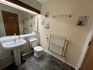 W łazience znajduje się umywalka, toaleta i lustro. w obiekcie Top Floor Room in Baker St w Londynie