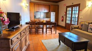 un salon avec une télévision et une salle à manger dans l'établissement Quinta do Burgo - Nature Hotel, à Amares