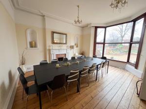 a dining room with a large black table and chairs at Beldon House in Brigg