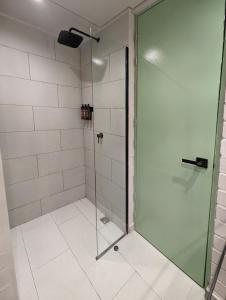 y baño con ducha y puerta de cristal. en Urbit Factory Lofts, en Medellín