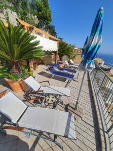 a row of lounge chairs and umbrellas on a beach at Lia's room - Il Monticello in Positano