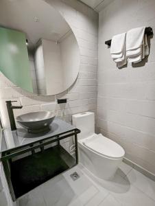 y baño con lavabo, aseo y espejo. en Urbit Factory Lofts, en Medellín