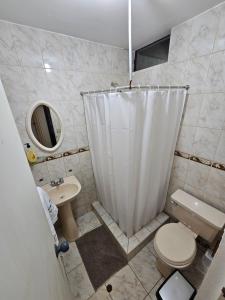 a bathroom with a white shower curtain and a toilet at Departamentos Cerca al mar in Lima