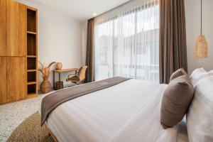 a bedroom with a bed and a large window at Sunny Village Berawa in Canggu