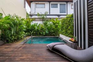 a swimming pool on a deck next to a building at Sunny Village Berawa in Canggu