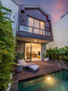 a house with a swimming pool in front of a house at Sunny Village Berawa in Canggu