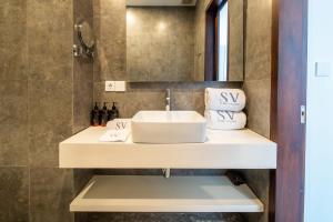 a bathroom with a sink and a mirror at Sunny Village Berawa in Canggu
