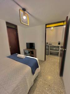 a bedroom with a bed and a desk and a mirror at Hotel Citadin Z10 in Guatemala