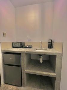 uma cozinha com um lavatório e um balcão com um lavatório em Hotel Citadin Z10 em Guatemala