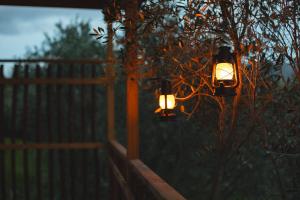 a couple of lights hanging on a fence at Le Fraine - Agriturismo & Olives Glamping in Santa Luce