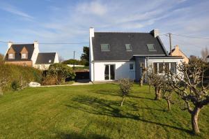 una casa bianca con un cortile con erba verde di Belle maison 3 etoiles dans la station touristique de Trebeurden à 1km de la mer - Réf 670 a Trébeurden