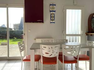 a kitchen with a table and chairs and a clock at Maison VUE MER, jardin, terrasse, WIFI, au SUD, à TREBEURDEN - Réf 663 in Trébeurden