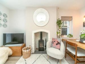 a living room with a fireplace and a table and a chair at Stunning flat Richmond Bridge Pass The Keys in Twickenham