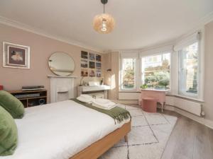 1 dormitorio con cama, espejo y lavamanos en Stunning flat Richmond Bridge Pass The Keys, en Twickenham