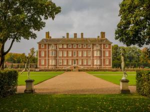 a large red brick building with a green lawn at Stunning flat Richmond Bridge Pass The Keys in Twickenham