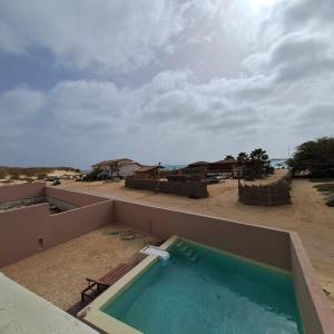 ein Pool an der Seite eines Gebäudes mit Strand in der Unterkunft APARTAMENTOS ESTORIL in Sal Rei