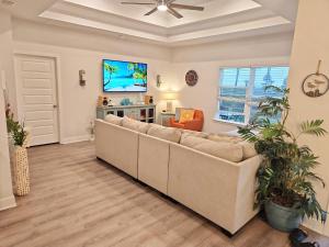 a living room with a couch and a tv at Coastal Dreaming - Beach Retreat in Saint Joe Beach