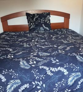 a bed with a blue and white blanket on it at Cosy Homestay Antony Parking libre in Antony