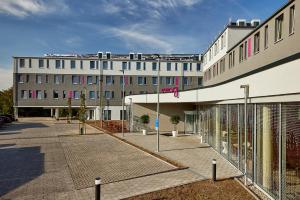a large white building with a courtyard in front of it at Moxy Karlsruhe in Karlsruhe