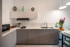 a kitchen with white cabinets and a sink at Sunny Village Berawa in Canggu