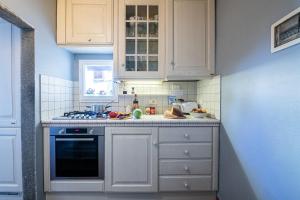 uma cozinha com armários brancos e um forno com placa de fogão em Parione loft in town center em Florença