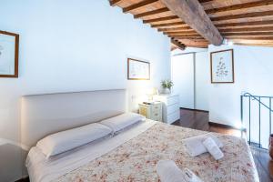 um quarto branco com uma cama grande e um tecto de madeira em Parione loft in town center em Florença