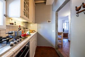 uma cozinha com armários brancos e um forno com placa de fogão em Parione loft in town center em Florença