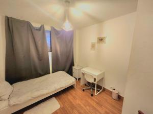 a small bedroom with a bed and a desk at Great room Saint-Denis (near Paris) in Saint-Denis