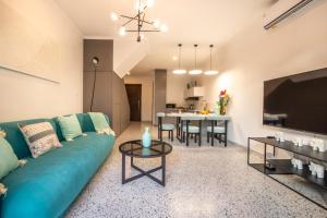 a living room with a blue couch and a table at Sunny Village Berawa in Canggu