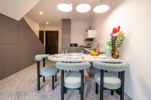 a kitchen with a white table and blue chairs at Sunny Village Berawa in Canggu