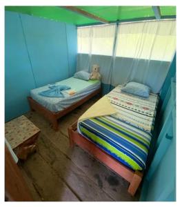 Un dormitorio con 2 camas y un osito de peluche. en Amazon tucuxi, en Mazán