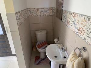 a small bathroom with a toilet and a sink at First derby Lodge in Benoni