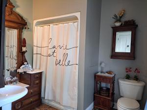 a bathroom with a shower curtain with the words faith of brilliance at Gîte au Charme Victorien in Beauceville