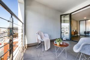 a balcony with chairs and a table with a view at Eazy Rio by ULIV in Tijuana