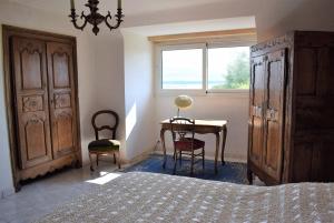 a bedroom with a bed and a desk and a window at Grande Maison VUE SUR MER 9 pers à Trébeurden - Réf 682 in Trébeurden