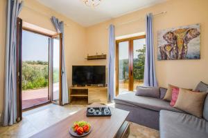 a living room with a couch and a tv at Villa Erato Klio in Kiriánna