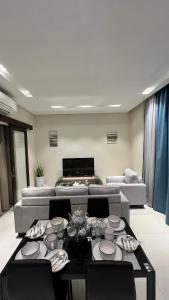 Hawana salalah Apartment Acacia في صلالة: غرفة معيشة مع طاولة وأريكة