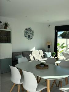 a white dining room with a table and chairs at Casa Blu Blu - Your Holidayhome with pool near the Beach! in Santiago de la Ribera