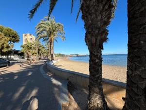 a sandy beach with palm trees and the ocean at Casa Blu Blu - Your Holidayhome with pool near the Beach! in Santiago de la Ribera